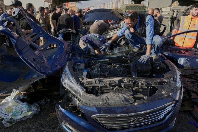 Menschen versammeln sich um ein zerstörtes Auto