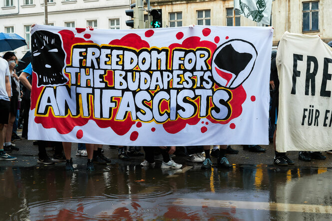 Demonstrierende tragen ein Banner, mit dem sie die Freiheit für die Antifaschisten fordern, die wegen der Budapest-Angriffe inhaftiert sind.
