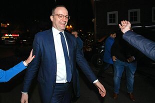 Jens Spahn läuft mit einem Lächeln im Gesicht durch die Nacht, Hände werden ihm entgegengestreckt