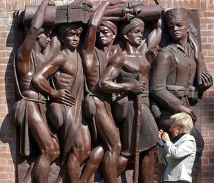 Eine Frau fotografiert das "Askari-Relief" im sogenannten "Tansania-Park" in Hamburg.