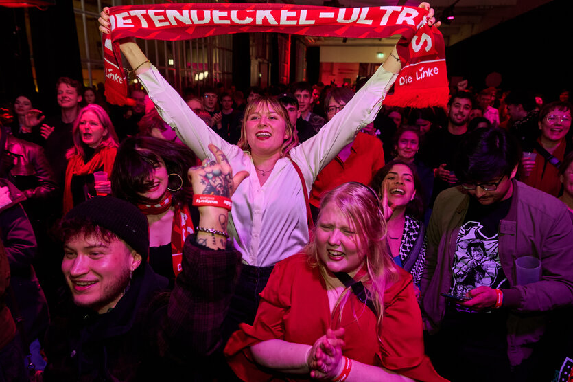 Wahlparty der Partei Die Linke: begeisterte Menge; eine junge Frau hält einen Schal hoch, auf dem steht: Mietendeckel-Ultras