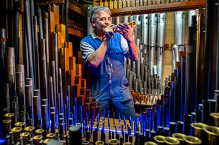 Porträt von Sven Wortmann vor einer Orgel.