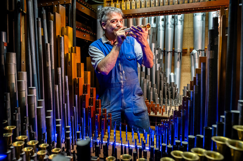 Porträt von Sven Wortmann vor einer Orgel.
