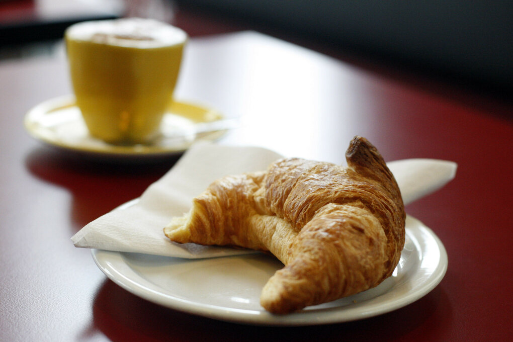 Croissant auf Teller mit Kaffee