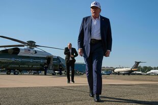 US-Präsident Donald Trump steht auf einem Flugfeld, im Hintergrund ein Hubschrauber