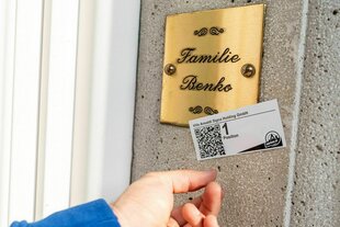 Ein Aufkleber mit einem QR Code klebt auf einem Klingelschild mit dem Namen Benko