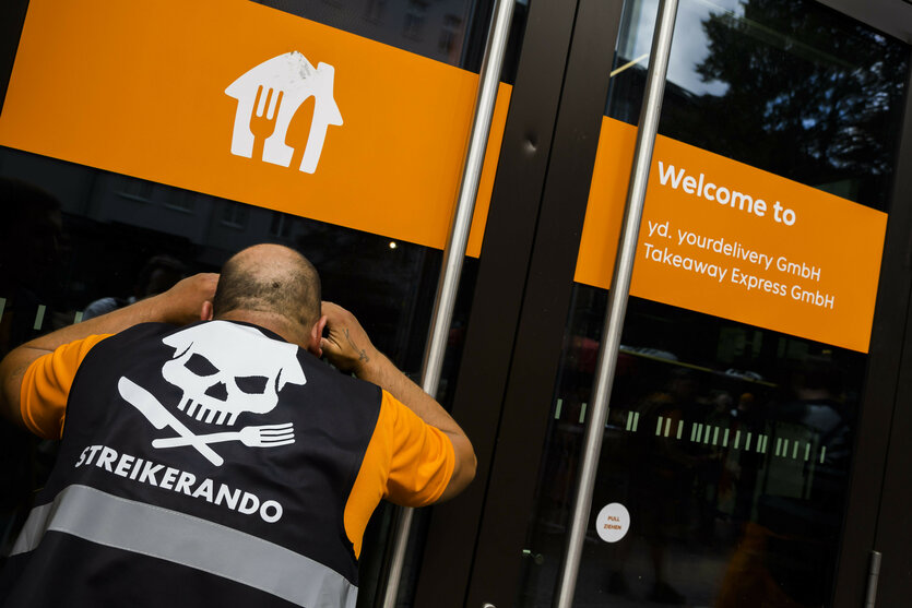 Fahrer vor der Lieferando-Zentrale: Er trägt eine Weste mit Totenkopf und der Aufschrift Streikerando