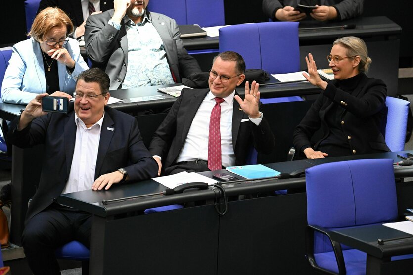 Drei Personen machen ein Selfie und winken dafür in die Kamera