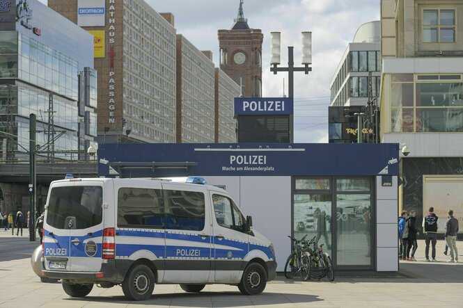 Ein Mannschaftswagen der Polizei steht vor einem kleinen Polizeihäuschen am Berliner Alexanderplatz