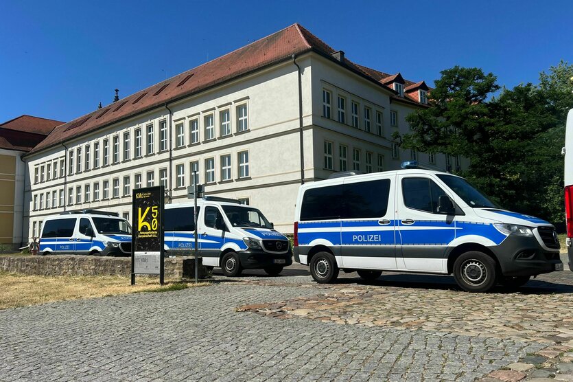 Drei Polizeiautos stehen vor dem Landtag in Magdeburg