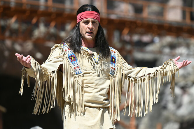 Alexander Klaws als Winnetou-Darsteller breitet im Kostüm und vor der Kulisse der Karl May Spiele in Bad Segeberg seine Arme aus