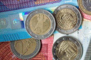 Euro Münzen und Scheine liegen übereinander