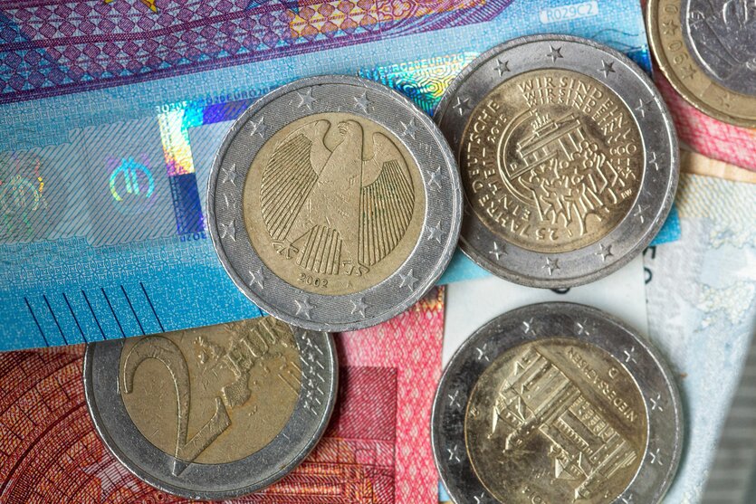 Euro Münzen und Scheine liegen übereinander