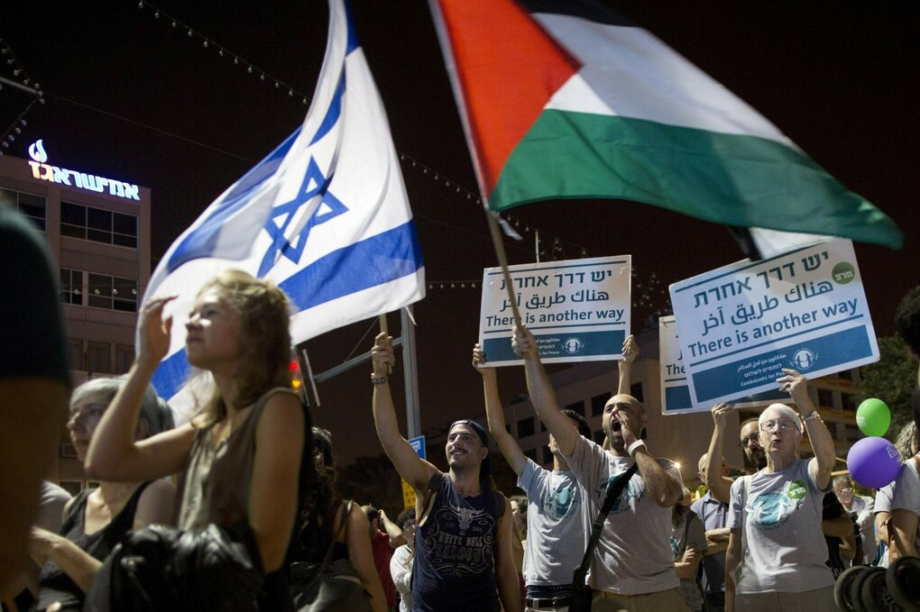Demonstranten schwenken bei einer Friedensdemonstration israelische und palästinensische Flaggen