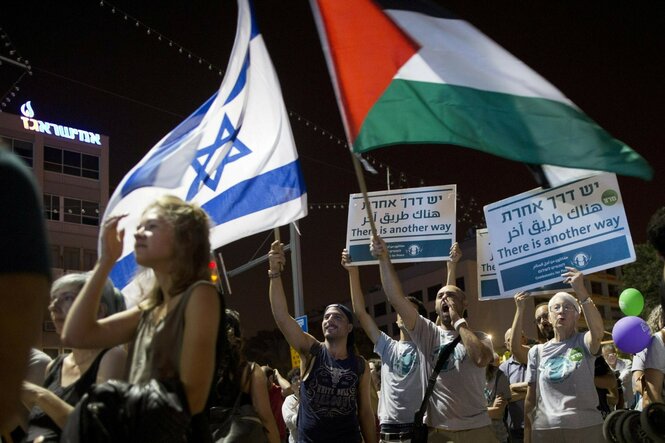 Demonstranten schwenken bei einer Friedensdemonstration israelische und palästinensische Flaggen