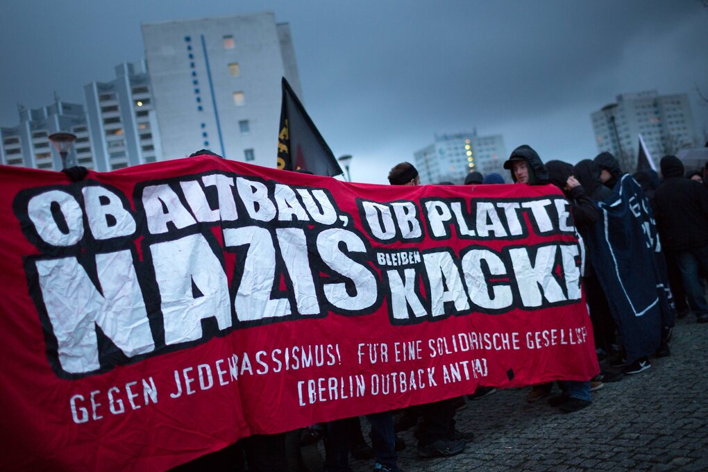 Demonstranten laufen im Plattenbau mit Banner: "Ob Altbau, ob Platte, Nazis bleiben Kacke."
