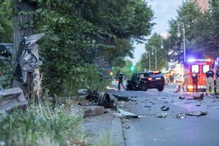 Ein Unfall durch Raserei : eine Fahrertür klebt an einem Baumstamm