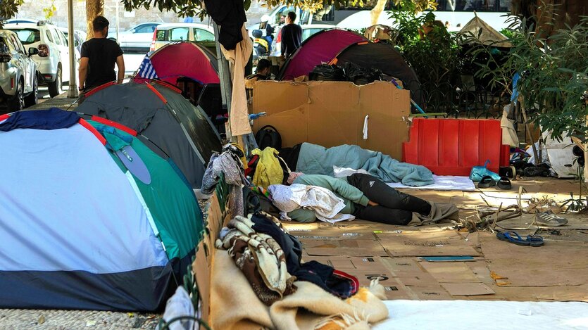 Obdachlos: kleine Zelte stehen auf dem Gehweg, der Boden ist mit Pappe abgedeckt, zwei Menschen schlafen