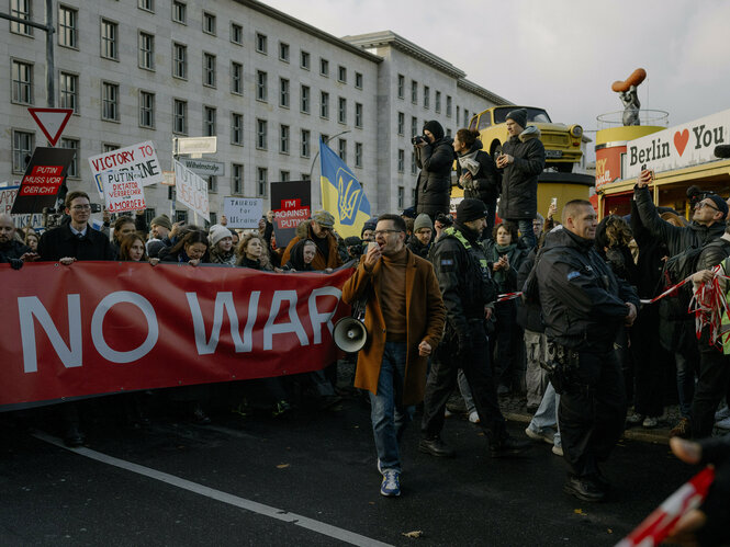 Ilja Jaschin steht mit einem Megaphon inmitten einer Demonstration auf einer Straße