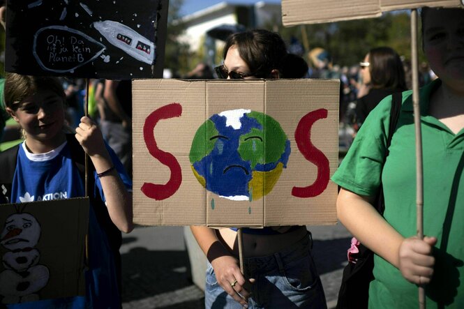 Demonstrant*innen der Fridays-for-Future-Bewegung mit Schild SOS