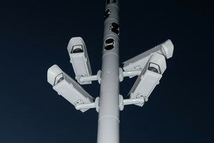 Ein Mast mit vier Überwachungskameras ragt in den Nachthimmel