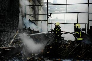 Feuerwehrleute bei Lösch­arbeiten nach dem großen Luftangriff auf das west­ukrainische Gebiet Wolyn am 9. Juli