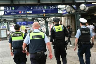 Vier Männer unterwegs am Hauptbahnhof in Hamburg: zwei Männer vom Sicherheitsdienst in Uniform und zwei Polizisten, die bewaffnet sind
