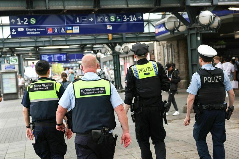 Vier Männer unterwegs am Hauptbahnhof in Hamburg: zwei Männer vom Sicherheitsdienst in Uniform und zwei Polizisten, die bewaffnet sind