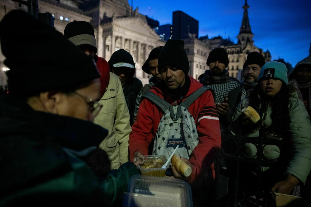 Obdachlose Menschen stehen bei kaltem Wetter für Essen an