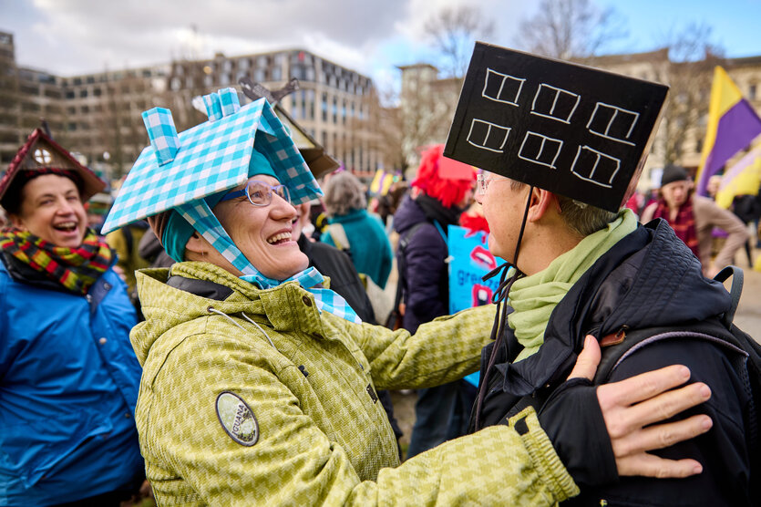 Demonstrantin mit Häuser als Kopfbedeckung
