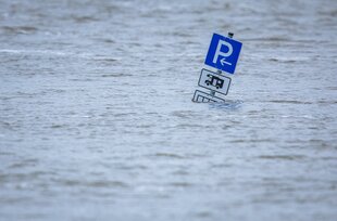 Ein Parkplatzschild für Wohnmobile steht im Hochwasser