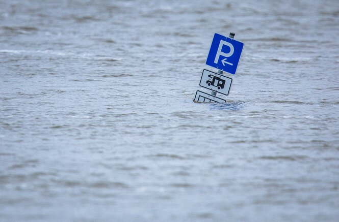 Ein Parkplatzschild für Wohnmobile steht im Hochwasser