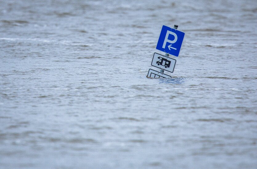 Ein Parkplatzschild für Wohnmobile steht im Hochwasser
