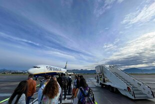 Passagiere warten auf dem Flughafen Bergamo auf die Ankunft des Ryanair-Flugzeuges, Alpenpanorama und blauster Himmel im Hintergrund