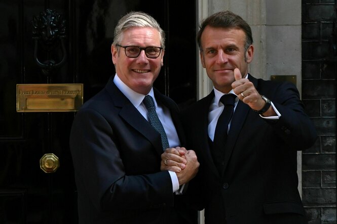 Keir Starmer empfängt Emmanuel Macron, beide schauen in die Kamera und lächeln, Macron reckt den Daumen hoch