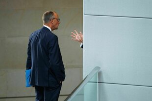 Merz, uns den Rücken zugewandt, im Bundestag