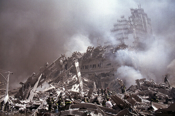 Archivbild 9/11; die rauchenden, staubigen Überreste des World Trade Centers, in den Trümmern, fast nicht unterscheidbar, Rettungskräfte