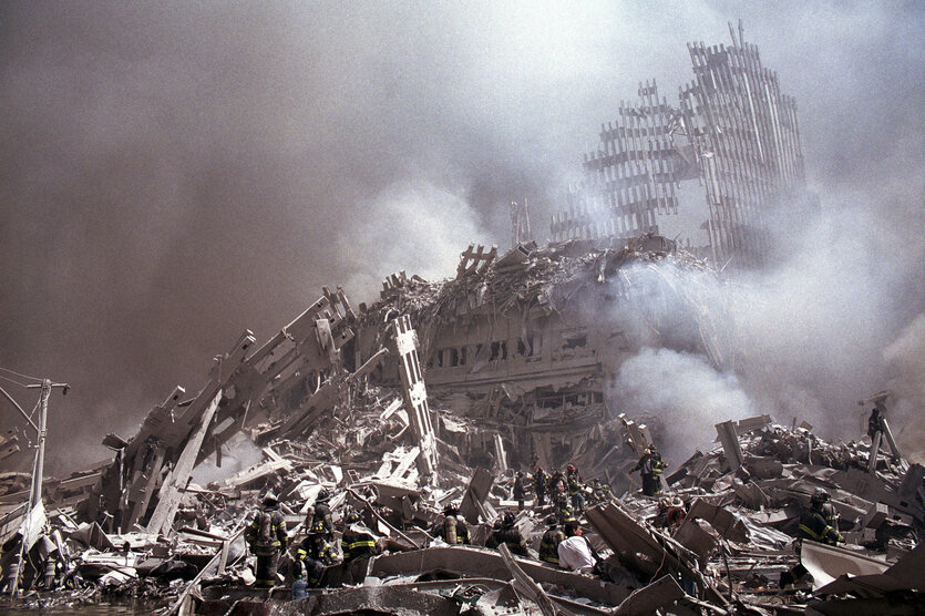 Archivbild 9/11; die rauchenden, staubigen Überreste des World Trade Centers, in den Trümmern, fast nicht unterscheidbar, Rettungskräfte