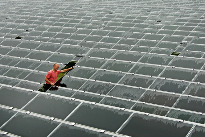 Ein Techniker kontrolliert Solar-Module von montierten und verkabelten Solarmodulen
