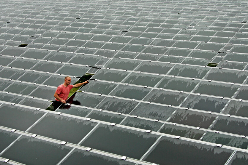 Ein Techniker kontrolliert Solar-Module von montierten und verkabelten Solarmodulen