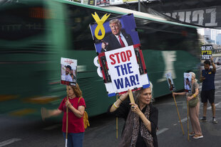 Eine Frau hält ein Schild mit der Aufschrift „Stop the War"
