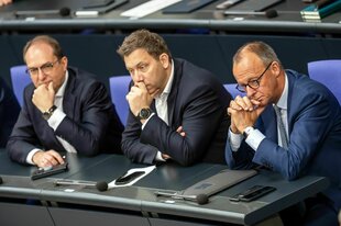 Friedrich Merz verfolgt die Debatte neben Lars Klingbeil und Alexander Dobrindt