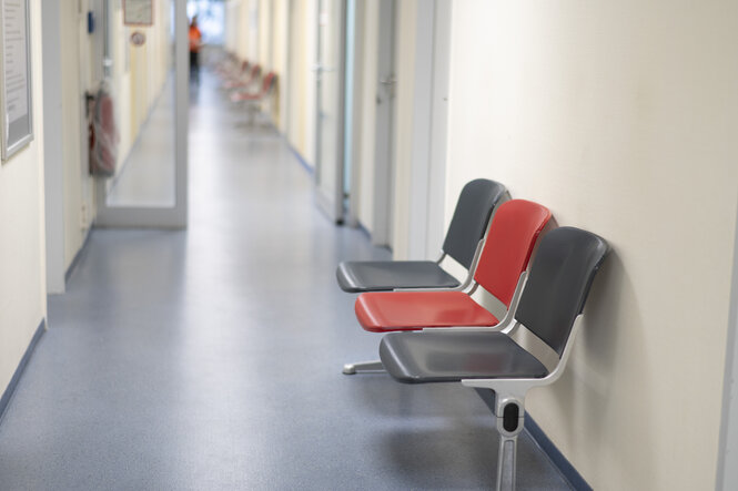 Leerer FLur eines Jobcenters, im Vordergrund eine Sitzbank mit drei leeren Sitzen