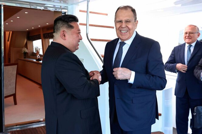 Kim Jong Un und Lawrow geben sich die Hand. Kim lächelt Lawrow an, Lawrow lächelt in die Kamera