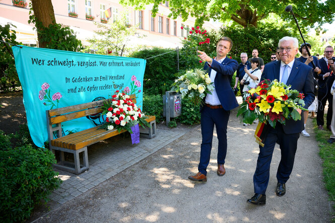 Bundespräsident Frank-Walter Steinmeier legt zusammen mit Nico Ruhle (SPD), Bürgermeister der Stadt Neuruppin, an der Gedenkstele für den von Rechtsextremisten getöteten Emil Wendland im Rosengarten Blumen nieder.