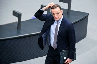 Ein Mann im Anzug fasst sich mit der Hand an den Kopf im Bundestag
