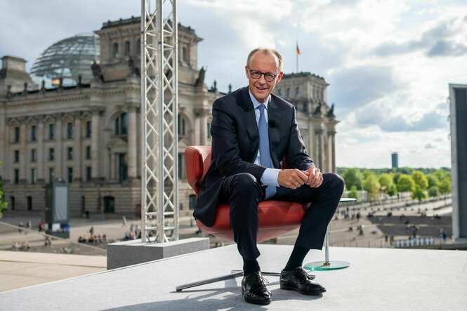 Merz beim Sommerinterview, im Hintergrund der Reichstag