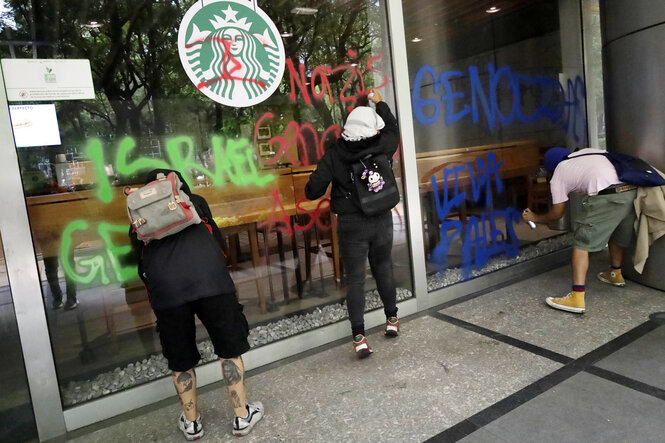 Personen besprühen ein Schaufenster.