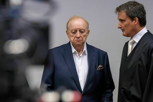 Zwei Männer stehen nebeneinander und schauen ernst