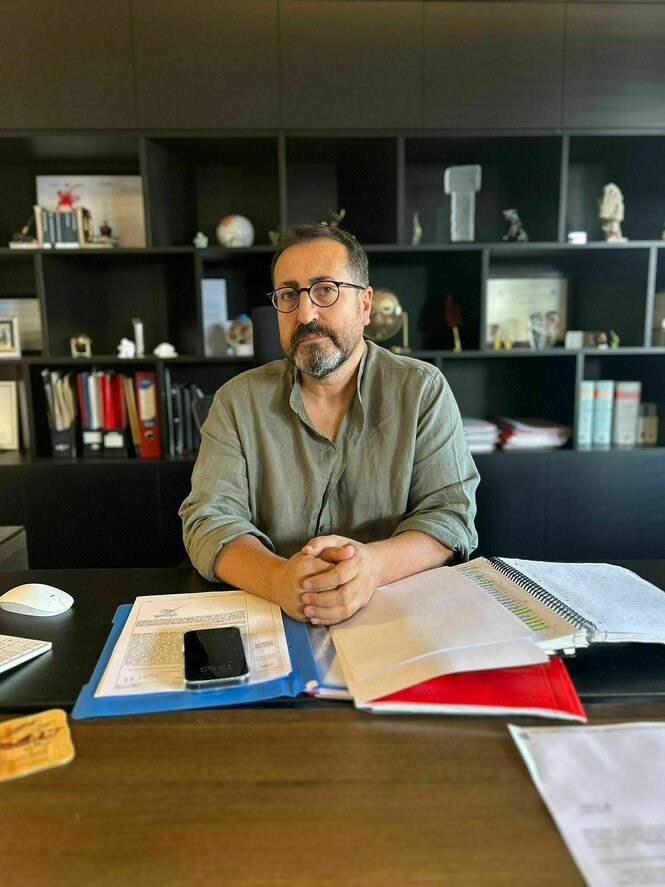 Mahmut Kacan sitzt an einem Schreibtisch
